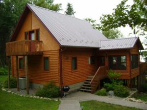 Whispering Pines projects log home exterior with upper deck and raised front entrance