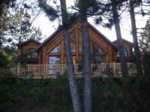 Whispering Pines projects home exterior with large log accents and front deck