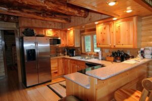 Whispering Pines projects interior log home kitchen with large log beams
