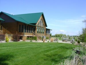 Whispering Pines projects log home side exterior and green lawn