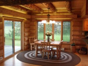 Whispering Pines projects log interior dining room with large wood beems