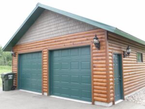 Whispering Pines projects log garage exterior with green doors