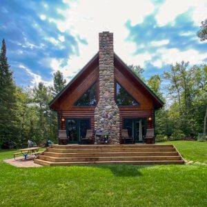 Whispering Pines projects log home back exterior with chimney