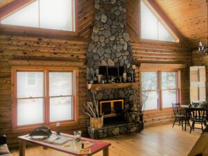 Whispering pines projects log interior main living room with large rock fireplace