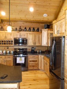 Whispering Pines projects log interior kitchen with pine cabinets